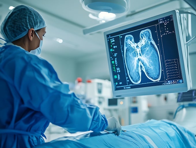 picture of health worker reading an x-ray image on an electronic display