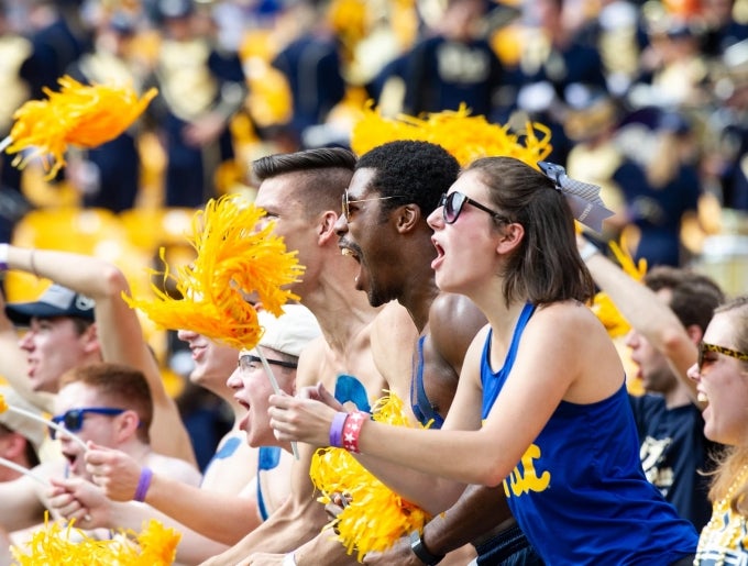 image of students cheering at a Pitt football game